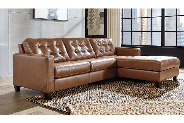 Bask in the beauty of the Baskove sectional. Reserved exclusively for those with an eye for fine contemporary design, this generously scaled sectional in auburn brown is dressed to impress in every way. Real leather throughout the seating area provides incomparable comfort where it counts. Sleek track armrests, tufted box cushions and a sumptuous chaise are the embodiment of luxury.Includes 2 pieces: right-arm facing corner chaise and left-arm facing loveseat | "Left-arm" and "right-arm" describe the position of the arm when you face the piece | Corner-blocked frame | Attached back and loose seat cushions | High-resiliency foam cushions wrapped in thick poly fiber | Leather interior upholstery; vinyl/polyester upholstery | Exposed feet with faux wood finish | Platform foundation system resists sagging 3x better than spring system after 20,000 testing cycles by providing more even support | Smooth platform foundation maintains tight, wrinkle-free look without dips or sags that can occur over time with sinuous spring foundations | Estimated Assembly Time: 5 Minutes