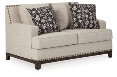 With its uniquely chic blend of elements, the Ballina loveseat breaks the rules in a beautiful way. Crisp and clean—with just a hint of classic flair—this designer loveseat stands out with its sleek track arms and prominent nailhead trim punctuating the linear profile. Truly setting this contemporary loveseat apart—an exposed walnut-tone rail for a high-end, furniture gallery aesthetic. Reversible cushions and decorative pillows in relaxed, muted hues make this loveseat befitting everything from modern farmhouse to urban chic spaces.Corner-blocked frame | Reversible cushions | High-resiliency foam cushions wrapped in thick poly fiber | Polyester upholstery | Throw pillows included | Pillows with soft polyfill | Exposed rail and feet with faux wood finish | Platform foundation system resists sagging 3x better than spring system after 20,000 testing cycles by providing more even support | Smooth platform foundation maintains tight, wrinkle-free look without dips or sags that can occur over time with sinuous spring foundations