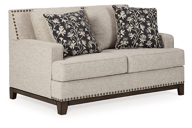 With its uniquely chic blend of elements, the Ballina loveseat breaks the rules in a beautiful way. Crisp and clean—with just a hint of classic flair—this designer loveseat stands out with its sleek track arms and prominent nailhead trim punctuating the linear profile. Truly setting this contemporary loveseat apart—an exposed walnut-tone rail for a high-end, furniture gallery aesthetic. Reversible cushions and decorative pillows in relaxed, muted hues make this loveseat befitting everything from modern farmhouse to urban chic spaces.Corner-blocked frame | Reversible cushions | High-resiliency foam cushions wrapped in thick poly fiber | Polyester upholstery | Throw pillows included | Pillows with soft polyfill | Exposed rail and feet with faux wood finish | Platform foundation system resists sagging 3x better than spring system after 20,000 testing cycles by providing more even support | Smooth platform foundation maintains tight, wrinkle-free look without dips or sags that can occur over time with sinuous spring foundations