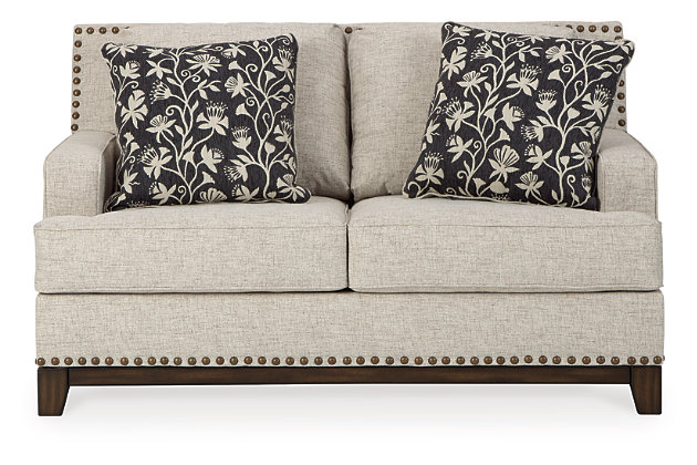 With its uniquely chic blend of elements, the Ballina loveseat breaks the rules in a beautiful way. Crisp and clean—with just a hint of classic flair—this designer loveseat stands out with its sleek track arms and prominent nailhead trim punctuating the linear profile. Truly setting this contemporary loveseat apart—an exposed walnut-tone rail for a high-end, furniture gallery aesthetic. Reversible cushions and decorative pillows in relaxed, muted hues make this loveseat befitting everything from modern farmhouse to urban chic spaces.Corner-blocked frame | Reversible cushions | High-resiliency foam cushions wrapped in thick poly fiber | Polyester upholstery | Throw pillows included | Pillows with soft polyfill | Exposed rail and feet with faux wood finish | Platform foundation system resists sagging 3x better than spring system after 20,000 testing cycles by providing more even support | Smooth platform foundation maintains tight, wrinkle-free look without dips or sags that can occur over time with sinuous spring foundations