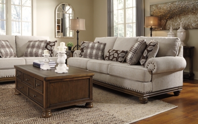 True classic character comes to life in the Harleson sofa. Set back pleated rolled arms and warm brown exposed frame with bun feet are beautifully traditional. Lovely detailing carries itself through the herringbone weave in the soft upholstery. Seat cushions reverse to maintain durable comfort. Vintage-inspired jumbo nailhead trim graces the design. Plaid and botanical pillows in dark brown are a timeless touch.Corner-blocked frame | Attached back and reversible seat cushions | High-resiliency foam cushions wrapped in thick poly fiber | 5 decorative pillows included | Pillows with soft polyfill | Polyester upholstery; Polyester/acrylic/linen and polyester pillows | Bronze-tone nailhead trim | Exposed feet with faux wood finish | Platform foundation system resists sagging 3x better than spring system after 20,000 testing cycles by providing more even support | Smooth platform foundation maintains tight, wrinkle-free look without dips or sags that can occur over time with sinuous spring foundations