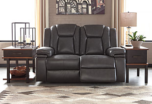 Wouldn’t it be great if the cool look of leather could be blended with the warm feel of fabric? Find a beautiful balance of contemporary style and cozy comfort in the Garristown power reclining loveseat. Sporting a sultry gray UltraPella upholstery, this chic faux leather power loveseat is empowering in every which way. The Easy View™ power headrest allows you the perfect view of the TV, even when you’re lying back. And if you’re never far from your cell phone or laptop, you’ll surely appreciate the one-touch power control with USB charging port.Dual-sided recliner | One-touch power control with adjustable positions | Corner-blocked frame with wooden seat box | Attached back and seat cushions | High-resiliency foam cushions wrapped in thick poly fiber | Easy View™ power adjustable headrest | Includes USB charging port in the power control | Polyester/polyurethane upholstery | Power cord included; UL Listed | Estimated Assembly Time: 30 Minutes