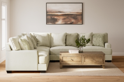 Beige 3 seater sectional couch with green and gray accent pillows