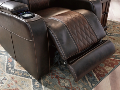 Movie nights will be forever changed with the Composer power recliner. The adjustable Easy View™ headrest allows a primo view of the TV no matter how far back you recline and the extended ottoman provides extra room to really stretch out. Ultra-cool lattice stitching elevates the look and ambient LED lighting completes the theater-style experience. So relax, kick off your shoes and enjoy the show.One-touch power control with adjustable positions | Corner-blocked frame with metal reinforced seat | Attached cushions | High-resiliency foam cushions wrapped in thick poly fiber | Easy View™ power adjustable headrest | Includes USB charging port in the power control | Extended ottoman for enhanced comfort | Ambient blue LED lighting on cup holders and base for a theater-style experience | Polyester/polyurethane upholstery | Power cord included; UL Listed | Estimated Assembly Time: 15 Minutes