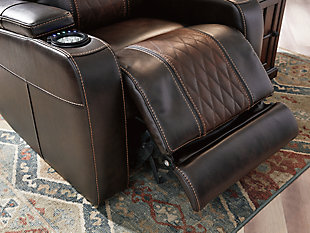 With its designer aesthetic and home movie theater features, the Composer power recliner hits a high note for style and comfort. Thanks to an adjustable Easy View™ headrest, you’ll have a primo view of the TV, no matter how far back you recline. Ultra-cool lattice stitching elevates the look of this modern power recliner. Ambient blue LED lighting on the base and cup holders completes the theater-style experience.One-touch power control with adjustable positions | Corner-blocked frame with metal reinforced seat | Attached cushions | High-resiliency foam cushions wrapped in thick poly fiber | Easy View™ power adjustable headrest | Includes USB charging port in the power control | Extended ottoman for enhanced comfort | Ambient blue LED lighting on the base and cup holders for a theater-style experience | Polyester/polyurethane upholstery | Power cord included; UL Listed | Estimated Assembly Time: 15 Minutes