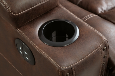 When it comes to style, you’ve got game. Rest assured, the Owner’s Box power recliner is sure to win you over with its ultra-cool looks and major league features. Showcasing all the bells and whistles, this designer recliner is inspired by sports car interiors—with a fabulous faux leather accentuated with horizontal channel tufting. An advanced one-touch power control with an Easy View™ power headrest puts you in the driver’s seat. Dual cup holders and armrests with hidden storage take the form and function to another level.One-touch power control with adjustable positions | Easy View™ adjustable headrest | Corner-blocked frame with metal reinforced seat | Attached cushions | High-resiliency foam cushions wrapped in thick poly fiber | Faux leather upholstery | Each armrest includes storage compartment and cup holder | Extended ottoman for enhanced comfort | Power cord included; UL Listed | Exposed feet with faux wood finish | Estimated Assembly Time: 15 Minutes