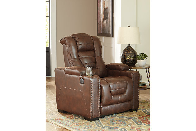 When it comes to style, you’ve got game. Rest assured, the Owner’s Box power recliner is sure to win you over with its ultra-cool looks and major league features. Showcasing all the bells and whistles, this designer recliner is inspired by sports car interiors—with a fabulous faux leather accentuated with horizontal channel tufting. An advanced one-touch power control with an Easy View™ power headrest puts you in the driver’s seat. Dual cup holders and armrests with hidden storage take the form and function to another level.One-touch power control with adjustable positions | Easy View™ adjustable headrest | Corner-blocked frame with metal reinforced seat | Attached cushions | High-resiliency foam cushions wrapped in thick poly fiber | Faux leather upholstery | Each armrest includes storage compartment and cup holder | Extended ottoman for enhanced comfort | Power cord included; UL Listed | Exposed feet with faux wood finish | Estimated Assembly Time: 15 Minutes
