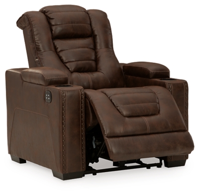 When it comes to style, you’ve got game. Rest assured, the Owner’s Box power recliner is sure to win you over with its ultra-cool looks and major league features. Showcasing all the bells and whistles, this designer recliner is inspired by sports car interiors—with a fabulous faux leather accentuated with horizontal channel tufting. An advanced one-touch power control with an Easy View™ power headrest puts you in the driver’s seat. Dual cup holders and armrests with hidden storage take the form and function to another level.One-touch power control with adjustable positions | Easy View™ adjustable headrest | Corner-blocked frame with metal reinforced seat | Attached cushions | High-resiliency foam cushions wrapped in thick poly fiber | Faux leather upholstery | Each armrest includes storage compartment and cup holder | Extended ottoman for enhanced comfort | Power cord included; UL Listed | Exposed feet with faux wood finish | Estimated Assembly Time: 15 Minutes