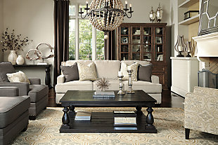 The generously scaled Mallacar coffee table in black has a dramatic presence—exactly what an eclectically styled room needs. Solid wood planks and thick veneer merge seamlessly together for a hearty helping of style. Handsomely turned legs connect to a lower shelf flush with the floor. A rustic wirebrush technique gives this stunning rectangular coffee table in black with show-through contrasting just enough of a weathered sensibility.Coffee table made of veneers, wood and engineered wood | Rich black finish with show-through effect | Lower shelf provides essential display and storage space | Made of veneers, wood and engineered wood | Saw cut planking | Rustic wirebrush details give the table a weathered aesthetic | Assembly required | Estimated Assembly Time: 15 Minutes