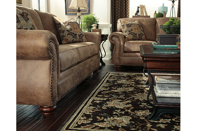 Dramatically transform your living space with the rustic look of weathered leather you love—at a fraction of the cost. That’s the beauty of the Larkinhurst faux leather loveseat. Washed in earthy Southwestern tones, with generous back and seating support and jumbo window-pane stitching, it envelops you in comfort and quality. Classic elements such as roll arms and turned feet bring in just enough traditional touch.Corner-blocked frame | Attached back and loose seat cushions | Cushions with ultra-supportive, pocketed coils | 2 decorative pillows included | Pillows with soft feather inserts; zippered access | Polyester/polyurethane upholstery; polyester/polyurethane and polyester pillows | Nailhead trim | Exposed feet with faux wood finish