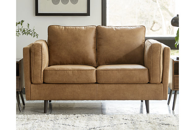 The Maimz loveseat is mid-century revival done to perfection. Linear and minimalistic, the beautifully edited profile has all the retro elements you love, like sheltering arms, bolster pillows and tapered splayed legs. So casually cool, the caramel faux leather upholstery brings the look right into the present.Corner-blocked frame | Reversible back and seat cushions | High-resiliency foam cushions wrapped in thick poly fiber | Polyester/polyurethane (faux leather) upholstery | Attached arm bolster pillows | Pillows with soft polyfill | Tapered splayed legs | Platform foundation system resists sagging 3x better than spring system after 20,000 testing cycles by providing more even support | Smooth platform foundation maintains tight, wrinkle-free look without dips or sags that can occur over time with sinuous spring foundations
