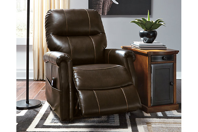 When it comes to exceptional comfort and style, the Markridge power lift recliner is right on the mark. This single motor lift recliner with 40" high back design has you covered from head to toe. Chocolate brown faux leather fabric is sure to blend beautifully in your space. Clean, transitional styling looks equally at home alongside contemporary and traditional decor.One-touch (hand control) power button with adjustable positions | Corner-blocked frame with metal reinforced seat | Attached cushions | 40" high back | High-resiliency foam cushions wrapped in thick poly fiber | Single-motor lift | Vinyl/polyester/polyurethane upholstery | Emergency battery backup runs on two 9-volt batteries (not included), in case of power outage | Power cord included; UL Listed | Estimated Assembly Time: 15 Minutes