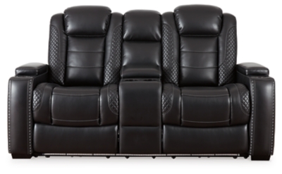 The Party Time power reclining loveseat takes its cue from luxury automobiles with lattice- and cross-hatch stitching, for a richly tailored aesthetic that gives you plenty of reasons to celebrate. Sumptuously padded cushions and dramatic midnight black faux leather upholstery add to the indulgence. When it’s time to rev up the action, the loveseat’s dual reclining bucket seats, Easy View™ power adjustable headrests and center console keep you in the driver’s seat. Dual-sided recliner | One-touch power controls with adjustable positions | Easy View™ power adjustable headrests | Corner-blocked frame with metal reinforced seats | Attached backs and seat cushions | High-resiliency foam cushions wrapped in thick poly fiber | Polyester/polyurethane upholstery | Includes USB charging port in each power control | Flip up padded armrests with hidden storage | Center console with cup holders and underneath storage | Ambient blue LED lighting on cup holders and base for a theater-style experience | Power cord included; UL Listed | Estimated Assembly Time: 15 Minutes