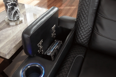 The Party Time power reclining loveseat takes its cue from luxury automobiles with lattice- and cross-hatch stitching, for a richly tailored aesthetic that gives you plenty of reasons to celebrate. Sumptuously padded cushions and dramatic midnight black faux leather upholstery add to the indulgence. When it’s time to rev up the action, the loveseat’s dual reclining bucket seats, Easy View™ power adjustable headrests and center console keep you in the driver’s seat. Dual-sided recliner | One-touch power controls with adjustable positions | Easy View™ power adjustable headrests | Corner-blocked frame with metal reinforced seats | Attached backs and seat cushions | High-resiliency foam cushions wrapped in thick poly fiber | Polyester/polyurethane upholstery | Includes USB charging port in each power control | Flip up padded armrests with hidden storage | Center console with cup holders and underneath storage | Ambient blue LED lighting on cup holders and base for a theater-style experience | Power cord included; UL Listed | Estimated Assembly Time: 15 Minutes