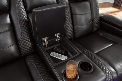 The Party Time power reclining loveseat takes its cue from luxury automobiles with lattice- and cross-hatch stitching, for a richly tailored aesthetic that gives you plenty of reasons to celebrate. Sumptuously padded cushions and dramatic midnight black faux leather upholstery add to the indulgence. When it’s time to rev up the action, the loveseat’s dual reclining bucket seats, Easy View™ power adjustable headrests and center console keep you in the driver’s seat. Dual-sided recliner | One-touch power controls with adjustable positions | Easy View™ power adjustable headrests | Corner-blocked frame with metal reinforced seats | Attached backs and seat cushions | High-resiliency foam cushions wrapped in thick poly fiber | Polyester/polyurethane upholstery | Includes USB charging port in each power control | Flip up padded armrests with hidden storage | Center console with cup holders and underneath storage | Ambient blue LED lighting on cup holders and base for a theater-style experience | Power cord included; UL Listed | Estimated Assembly Time: 15 Minutes