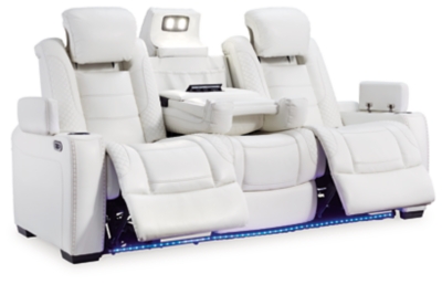 The Party Time power reclining sofa takes its cue from luxury automobiles with lattice and crosshatch stitching, for a richly tailored aesthetic that gives you plenty of reasons to celebrate. Sumptuously padded cushions and crisp white faux leather upholstery add to the indulgence. When it’s time to rev up the action, the dual reclining bucket seats (middle seat is stationary), Easy View™ power adjustable headrests and a center seat that folds down into a table keep you in the driver’s seat.Dual-sided recliner | Polyester/polyurethane upholstery | Corner-blocked frame with metal reinforced seat | Attached back and seat cushions | High-resiliency foam cushions wrapped in thick poly fiber | One-touch power control with adjustable positions, Easy View™ adjustable headrest and USB plug-in | Flip up padded armrests with hidden storage | Drop down table with 2 cup holders and a handy docking station for charging electronics | Flip up LED light (under center seat headrest) | Ambient blue LED lighting on cup holders and base for a theater-style experience | Power cord included; UL Listed | Estimated Assembly Time: 15 Minutes