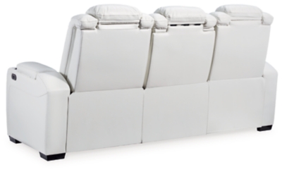 The Party Time power reclining sofa takes its cue from luxury automobiles with lattice and crosshatch stitching, for a richly tailored aesthetic that gives you plenty of reasons to celebrate. Sumptuously padded cushions and crisp white faux leather upholstery add to the indulgence. When it’s time to rev up the action, the dual reclining bucket seats (middle seat is stationary), Easy View™ power adjustable headrests and a center seat that folds down into a table keep you in the driver’s seat. Ambient blue LED lighting on the base and cup holders completes the theater-style experience.Dual-sided recliner | Polyester/polyurethane upholstery | Corner-blocked frame with metal reinforced seat | Attached back and seat cushions | High-resiliency foam cushions wrapped in thick poly fiber | One-touch power control with adjustable positions, Easy View™ adjustable headrest and USB plug-in | Flip up padded armrests with hidden storage | Drop down table with 2 cup holders and a handy docking station for charging electronics | Flip up LED light (under center seat headrest) | LED lighting on cup holders and base for theater-style experience | Power cord included; UL Listed | Estimated Assembly Time: 15 Minutes