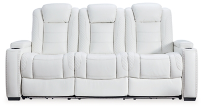 The Party Time power reclining sofa takes its cue from luxury automobiles with lattice and crosshatch stitching, for a richly tailored aesthetic that gives you plenty of reasons to celebrate. Sumptuously padded cushions and crisp white faux leather upholstery add to the indulgence. When it’s time to rev up the action, the dual reclining bucket seats (middle seat is stationary), Easy View™ power adjustable headrests and a center seat that folds down into a table keep you in the driver’s seat.Dual-sided recliner | Polyester/polyurethane upholstery | Corner-blocked frame with metal reinforced seat | Attached back and seat cushions | High-resiliency foam cushions wrapped in thick poly fiber | One-touch power control with adjustable positions, Easy View™ adjustable headrest and USB plug-in | Flip up padded armrests with hidden storage | Drop down table with 2 cup holders and a handy docking station for charging electronics | Flip up LED light (under center seat headrest) | Ambient blue LED lighting on cup holders and base for a theater-style experience | Power cord included; UL Listed | Estimated Assembly Time: 15 Minutes