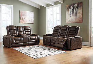 If you’re looking for the perfect seat for gaming, lounging or just relaxing, look no further than the indulgent comfort of the Game Zone power reclining sofa. Sporting one-touch power controls, Easy View™ power adjustable headrests, cup holders, storage and chargers, this dual-sided reclining sofa has everything you need for binge-watching or power playing. Padded cushions with waterfall back design and pillow top arms offer plenty of support, while leather alternative upholstery is given tuck and roll styling for a well-edited aesthetic. The stationary middle seat has hidden depths, just fold it forward to reveal a table-top with cup holders, USB charging a storage pocket and overhead lights. How’s that for handy?Dual-sided recliner | Polyurethane/polyester tuck and roll upholstery | Corner-blocked frame with metal reinforced seat | Attached back and seat cushions | High-resiliency foam cushions wrapped in thick poly fiber | One-touch power controls with adjustable positions | Includes USB charging port in each power control | Easy View™ power adjustable headrests | Cup holders; flip up padded armrests with hidden storage underneath | Drop down table with 2 cup holders and a handy docking station for charging electronics | Flip up LED light (under center seat headrest) | Nailhead trim | Power cord included; UL Listed | Estimated Assembly Time: 15 Minutes