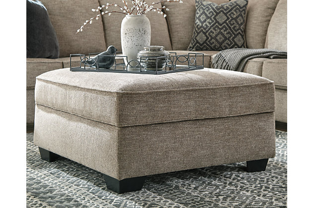 Whether your style is clean and contemporary or cozy modern farmhouse, the Bovarian ottoman in a stone-tone neutral upholstery has the corner on style. Merging ultimate comfort with striking good looks, this alluring ottoman makes itself useful with a hidden storage area for this, that and the other.Firmly cushioned | Corner-blocked frame | High-resiliency foam cushion wrapped in thick poly fiber | Textured polyester chenille upholstery | Storage under removable cushioned top | Exposed feet with faux wood finish