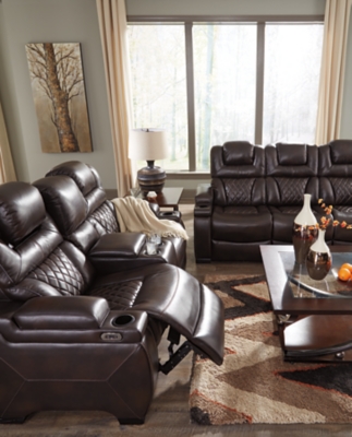 Your modern living room awaits with the Warnerton power reclining sofa. Complete with practical faux leather upholstery, one-touch power controls, adjustable headrests and USB ports, it makes finding the best seat in the house a breeze. What a perk that the center seat is crafted with a drop-down table with power/USB plug-ins and dual cup holders. Armrests with storage and cup holders keep drinks, snacks and remotes close by. Go ahead—treat yourself to a high-design home theater experience, priced to put you at ease.Dual-sided recliner; middle seat remains stationary | One-touch power controls with adjustable positions | Corner-blocked frame with metal reinforced seat | Attached cushions | High-resiliency foam cushions wrapped in thick poly fiber | Easy View™ power adjustable headrests | Each armrest with flip-top storage and cup holder | Drop-down table with AC power/USB plug-ins and 2 cup holders | USB charging port in power control | Polyester/polyurethane upholstery | Power cord included; UL Listed | Estimated Assembly Time: 30 Minutes