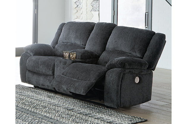 Built for luxury, the Draycoll power reclining loveseat with center console lets you kick back in reliable style. The thick, softly textured chenille upholstery provides a comfy surface on which to lounge. With bustle back construction and thickly cushioned armrests, this piece gives you the dependable, powered support you need to unwind with the convenience of the center console to ease your evening.Dual-sided recliner | One-touch power control with adjustable positions and zero-draw USB plug-in | Zero-draw technology only consumes power when the USB receptacle is in use | Corner-blocked frame with metal reinforced seat | Attached cushions | High-resiliency foam cushions wrapped in thick poly fiber | Polyester upholstery | Storage console with 2 cup holders | Power cord included; UL Listed | Estimated Assembly Time: 15 Minutes