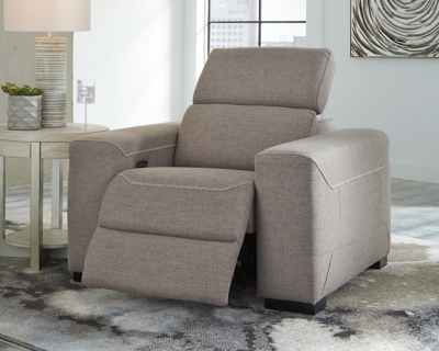 The challenge: Design a cutting-edge power recliner you’d never guess was a recliner. Super sleek and streamlined, the Mabton power recliner in taupe gray with high-contrast jumbo stitching might just be our best-kept secret. Rest assured, you’d be hard-pressed to find a modern recliner that looks so high end yet is so comfortably priced. Integrated elements include an Easy View™ adjustable headrest that offers low-profile style when it’s down and a high level of comfort when you’re kicking back and reclining. Factor in a one-touch power control (with a USB port) placed on the inside track arm, and you have the makings for one beautifully deceptive piece of furniture.One-touch power control with adjustable positions, Easy View™ adjustable headrest and USB plug-in | Corner-blocked frame | Attached cushions | High-resiliency foam cushions wrapped in thick poly fiber | Soft textured polyester upholstery | Power cord included; UL Listed | Exposed black feet | Estimated Assembly Time: 15 Minutes