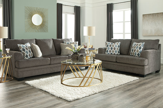 The Dorsten contemporary sofa and loveseat set has comfort written all over it. From the plush cushions to the textured gray fabric, it’s a total winner for relaxation. Designer throw pillows in blue, brown and tan complement the neutral upholstery.Includes sofa and loveseat | Corner-blocked frame | Attached back and loose seat cushions | High-resiliency foam cushions wrapped in thick poly fiber | Toss pillows included | Pillows with soft polyfill | Polyester upholstery and pillows | Exposed feet with faux wood finish | Sofa and loveseat with platform foundation system resists sagging 3x better than spring system after 20,000 testing cycles by providing more even support | Smooth platform foundation maintains tight, wrinkle-free look without dips or sags that can occur over time with sinuous spring foundations