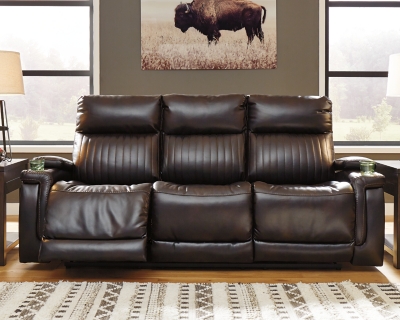 If you agree it’s time to put the high design in recline, prepare to be impressed with the Team Time power reclining sofa in chocolate brown. Equipped with everything from a power adjustable headrest and USB charging ports, to stainless steel cup holders and chic padded armrests, it’s the clear winner for contemporary style and comfort. Ultra-cool vertical channel stitching, jumbo contrast stitching and a pad-on-pad arm design put this power reclining sofa in a class by itself.Dual-sided recliner | One-touch power control with Easy View™ power adjustable headrest and USB plug-in | Corner-blocked frame with metal reinforced seat | Attached cushions | 42" high back | Drop-down table with 2 cup holders and a magazine holder | Stainless steel cup holder on each armrest | High-resiliency foam cushions wrapped in thick poly fiber | Polyester/polyurethane (faux leather) upholstery | Extended ottoman for enhanced comfort | Power cord included; UL Listed | Estimated Assembly Time: 15 Minutes