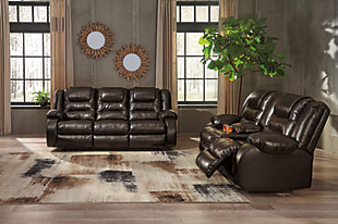 When it comes to comfort, style and value, the Vacherie faux leather reclining sofa in chocolate brown rocks. Tailored for feel-good flair, its fashion-forward bustle back design is enhanced with sculpted padding on the headrest for cradling support. Channel cushioning along the sides flows into thick, wrapped pillow top armrests that are truly over the top. And while it might look like you broke the bank, a sumptuously soft leather-like fabric keeps indulgence well within budget.Dual-sided recliner; middle seat remains stationary | Pull tab reclining motion | Corner-blocked frame with metal reinforced seat | Attached back and seat cushions | High-resiliency foam cushions wrapped in thick poly fiber | Vinyl/polyester/polyurethane upholstery