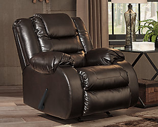 When it comes to comfort, style and value, the Vacherie faux leather rocker recliner in chocolate brown rocks. Tailored for feel-good flair, its fashion-forward bustle back design is enhanced with sculpted padding on the headrest for cradling support. Channel cushioning along the sides flows into thick, wrapped pillow top armrests that are truly over the top. And while it might look like you broke the bank, a sumptuously soft leather-like fabric keeps indulgence well within budget.Gentle rocking motion | Pull tab reclining motion | Corner-blocked frame with metal reinforced seat | Attached back and seat cushions | High-resiliency foam cushions wrapped in thick poly fiber | Vinyl/polyester/polyurethane upholstery | Excluded from promotional discounts and coupons