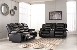 When it comes to comfort, style and value, the Vacherie faux leather reclining sofa in black rocks. Tailored for feel-good flair, its fashion-forward bustle back design is enhanced with sculpted padding on the headrest for cradling support. Channel cushioning along the sides flows into thick, wrapped pillowtop armrests that are truly over the top. And while it might look like you broke the bank, a sumptuously soft leather-like fabric keeps indulgence well within budget.Dual-sided recliner; middle seat remains stationary | Pull tab reclining motion | Corner-blocked frame with metal reinforced seat | Attached back and seat cushions | High-resiliency foam cushions wrapped in thick poly fiber | Vinyl/polyester/polyurethane upholstery