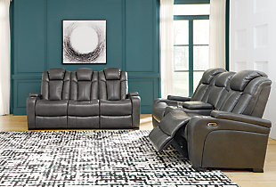 Looking for seating with all the bells and whistles? The Turbulance power reclining sofa has you covered. Get double the relaxation—recline your body then adjust your headrest. Pull down the middle seat to reveal a drop down table ready to hold your magazines and remotes. With USB charging ports, your devices will enjoy this sofa, too. Stainless steel cup holders accompany you on either side. All wrapped up in quality faux leather with fashion-forward jumbo stitching for a look and feel you’ll love.One-touch power control with adjustable positions | Easy View™ power adjustable headrests | Includes USB charging port in each power control | Corner-blocked frame with metal reinforced seat | Attached back and seat cushions | High-resiliency foam cushions wrapped in thick poly fiber | Vinyl/polyester upholstery | Drop-down center table with AC Power and 2 stainless steel cup holders | Hidden armrest storage compartments | Power cord included; UL Listed | Estimated Assembly Time: 15 Minutes