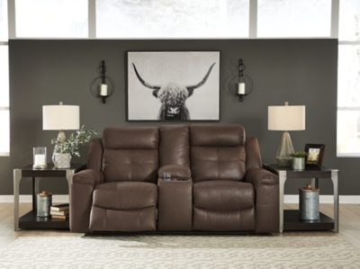 Rustic character comes forth in the warm brown Jesolo reclining loveseat. Designer stitching adds a fashion-forward touch to the soft cushions. Faux suede fabric speaks to your knack for superior-quality materials. High back provides ample support as you get off your feet for a bit. With just one pull of tab, you’ll be easing back into relaxation and popping your favorite beverage into a cup holder. Infinite levels of comfort await.Corner-blocked frame with metal reinforced seat | Attached back and seat cushions | Pull tab reclining motion | Lift-top storage console and 2 cup holders | High-resiliency foam cushions wrapped in thick poly fiber | Polyester/polyurethane upholstery | Estimated Assembly Time: 15 Minutes