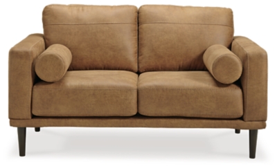 For a fresh spot in your space, turn to the Arroyo loveseat. This invigorating piece breathes warmth into your home with its striking caramel faux leather upholstery, modern bolster pillows and tapered legs. Wind down at the end of a long day when you sink into this canyon of comfort.Corner-blocked frame | High-resiliency foam cushions wrapped in thick poly fiber | Non-reversible loose seat and back cushions | Metal seat base | Polyester and polyurethane (faux leather) upholstery | 2 bolster pillows | Exposed legs with faux wood finish | Minor assembly (simply attach legs) | Estimated Assembly Time: 15 Minutes