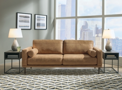 For a fresh spot in your space, turn to the Arroyo sofa. This invigorating piece breathes warmth into your home with its striking caramel faux leather upholstery, modern bolster pillows and tapered legs. Wind down at the end of a long day when you sink into this canyon of comfort.Corner-blocked frame | High-resiliency foam cushions wrapped in thick poly fiber | Non-reversible loose seat and back cushions | Metal seat base | Polyester and polyurethane (faux leather) upholstery | 2 bolster pillows | Exposed legs with faux wood finish | Minor assembly (simply attach legs) | Estimated Assembly Time: 15 Minutes