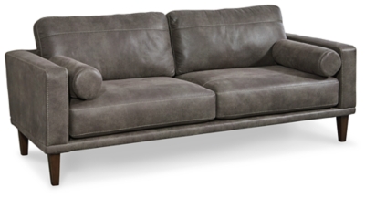 For a fresh spot in your space, turn to the Arroyo designer sofa. This invigorating piece breathes warmth into your home with its striking gray faux leather upholstery, modern bolster pillows and tapered legs. Wind down at the end of a long day when you sink into this canyon of comfort.Corner-blocked frame | High-resiliency foam cushions wrapped in thick poly fiber | Non-reversible loose seat and back cushions | Metal seat base | Polyester/polyurethane upholstery | 2 bolster pillows | Exposed legs with faux wood finish | Minor assembly (simply attach legs) | Estimated Assembly Time: 15 Minutes