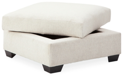 Let it snow. Doubling your pleasure with its combination of form and function, the Cambri storage ottoman in a snow-tone chenille fabric invites you to stretch your style in an easy-elegant way. Whether your aesthetic is urban hip or suburban chic, this posh ottoman with removable cushioned top and loads of handy storage is sure to look and feel right at home. And how’s this for a welcome surprise: a built-in tabletop with cup holders on the flip side!Corner-blocked frame | High-resiliency foam cushion wrapped in thick poly fiber | Polyester upholstery | Storage under cushioned removable top | Built-in tabletop/cup holders on reverse side of removable cushion | Exposed legs with faux wood finish