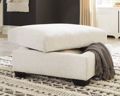 Let it snow. Doubling your pleasure with its combination of form and function, the Cambri storage ottoman in a snow-tone chenille fabric invites you to stretch your style in an easy-elegant way. Whether your aesthetic is urban hip or suburban chic, this posh ottoman with removable cushioned top and loads of handy storage is sure to look and feel right at home. And how’s this for a welcome surprise: a built-in tabletop with cup holders on the flip side!Corner-blocked frame | High-resiliency foam cushion wrapped in thick poly fiber | Polyester upholstery | Storage under cushioned removable top | Built-in tabletop/cup holders on reverse side of removable cushion | Exposed legs with faux wood finish