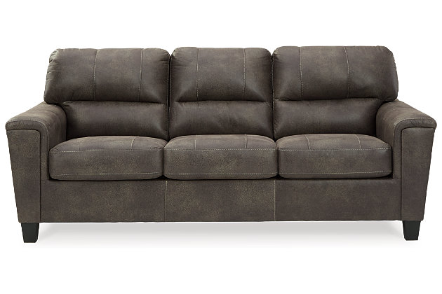 If you love the cool look of leather but long for the warm feel of fabric, you can take comfort in the Navi sofa sleeper. Wrapped in a fabulous faux leather with a weathered hue and hint of pebbly texture to resemble the real deal, this decidedly modern sofa proves less is more. Elements include angled side profiling and track armrests wrapped with a layer of pillowy softness for that little something extra. Prominent jumbo stitching and clean-lined divided back styling lend fashion-forward flair. Rest assured, the memory foam mattress comfortably accommodates overnight guests.Corner-blocked frame | Attached back and loose seat cushions | High-resiliency foam cushions wrapped in thick poly fiber | Polyester and polyurethane (faux leather) upholstery | Exposed feet with faux wood finish | Included bi-fold memory foam mattress sits atop a supportive steel frame | Memory foam provides better airflow for a cooler night’s sleep | Memory foam encased in damask tic