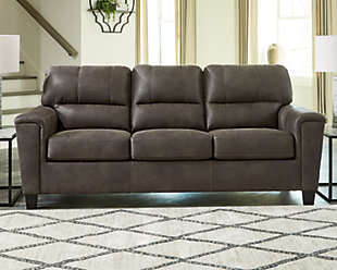 If you love the cool look of leather but long for the warm feel of fabric, you can take comfort in the Navi sofa. Wrapped in a fabulous faux leather with a weathered hue and hint of pebbly texture to resemble the real deal, this decidedly modern sofa proves less is more. Elements include angled side profiling and track armrests wrapped with a layer of pillowy softness for that little something extra. Prominent jumbo stitching and clean-lined divided back styling lend fashion-forward flair.Corner-blocked frame | Attached back and loose seat cushions | High-resiliency foam cushions wrapped in thick poly fiber | Polyester and polyurethane (faux leather) upholstery | Exposed feet with faux wood finish | Platform foundation system resists sagging 3x better than spring system after 20,000 testing cycles by providing more even support | Smooth platform foundation maintains tight, wrinkle-free look without dips or sags that can occur over time with sinuous spring foundations
