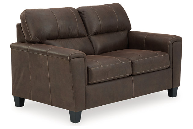 If you love the cool look of leather but long for the warm feel of fabric, you can take comfort in the Navi loveseat. Wrapped in a fabulous faux leather with a weathered hue and hint of pebbly texture to resemble the real deal, this decidedly modern loveseat proves less is more. Elements include angled side profiling and track armrests wrapped with a layer of pillowy softness for that little something extra. Prominent jumbo stitching and clean-lined divided back styling lend fashion-forward flair.Corner-blocked frame | Attached back and loose seat cushions | High-resiliency foam cushions wrapped in thick poly fiber | Polyester and polyurethane (faux leather) upholstery | Exposed feet with faux wood finish | Platform foundation system resists sagging 3x better than spring system after 20,000 testing cycles by providing more even support | Smooth platform foundation maintains tight, wrinkle-free look without dips or sags that can occur over time with sinuous spring foundations