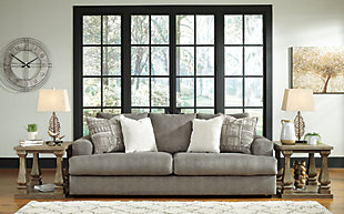Flaunting a trendsetting silhouette, the Soletren sofa puts the contemporary in your contemporary home. Its “three over two” profile eliminates the center seat cushion, giving you elongated plushness and deep seating. Microfiber fabric satisfies your need for a piece that feels as good as it looks. Accented with soft jacquard chenille throw pillows for a splash of geometric pattern and color contrast.Corner-blocked frame | Attached back and loose seat cushions | High-resiliency foam cushions wrapped in thick poly fiber | Platform foundation system resists sagging 3x better than spring system after 20,000 testing cycles by providing more even support | Smooth platform foundation maintains tight, wrinkle-free look without dips or sags that can occur over time with sinuous spring foundations | 4 decorative pillows included | Pillows with soft polyfill | Polyester upholstery and polyester pillows | Exposed feet with faux wood finish