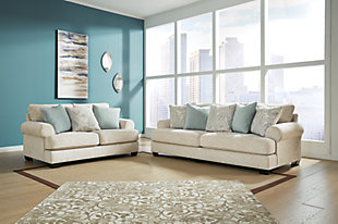The Monaghan sofa and loveseat strike a beautiful balance between classic and current. Traditional elements include t-cushion seating and setback roll arms, angled for modern flair. Posh collection of pillows in spa mist and jacquard paisley make a muted, mellow complement to the sofa’s casual textured chenille upholstery. Choice of sandstone beige is a light and lovely style awakening.Includes sofa and loveseat | Plush seating | Corner-blocked frame | Reversible cushions | High-resiliency foam cushions wrapped in thick poly fiber | Toss pillows included | Pillows with soft polyfill | Polyester upholstery; polyester and polyester/linen pillows | Exposed feet with faux wood finish | Sofa and loveseat with platform foundation system resists sagging 3x better than spring system after 20,000 testing cycles by providing more even support | Smooth platform foundation maintains tight, wrinkle-free look without dips or sags that can occur over time with sinuous spring foundations