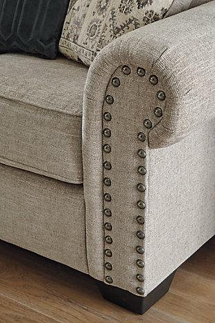 The Zarina sofa lets you make a high-style statement at a comfortably affordable price. Richly traditional roll arms are given a modern punch care of oversized nailhead trim in a black nickel-tone finish. Linen-weave upholstery in fresh and clean sandstone beige is complemented with designer pillows that add texture and sophistication.Corner-blocked frame | Attached back and loose seat cushions | High-resiliency foam cushions wrapped in thick poly fiber | Platform foundation system resists sagging 3x better than spring system after 20,000 testing cycles by providing more even support | Smooth platform foundation maintains tight, wrinkle-free look without dips or sags that can occur over time with sinuous spring foundations | 5 toss pillows included | Pillows with soft polyfill | Polyester upholstery; polyester and polyester/chenille pillows | Black nickel-tone nailhead trim | Exposed feet with faux wood finish