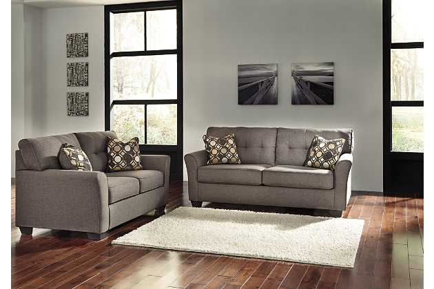 Inspired by high-end menswear, the Tibbee sofa and loveseat set is tailored to perfection and dressed to impress. Button-less tufting on the back cushions is richly subtle. Sleek, flared armrests enhance the clean-lined, striking profile.Includes sofa and loveseat | Corner-blocked frame | Attached back and loose seat cushions | High-resiliency foam cushions wrapped in thick poly fiber | Accent pillows included | Pillows with soft polyfill | Polyester upholstery and pillows | Exposed feet with faux wood finish