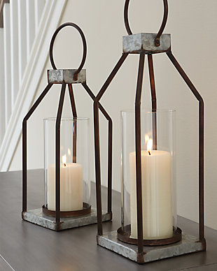Whoever said you couldn’t illuminate in style? This set of Diedrick lanterns act as beautiful vessels for the romantic glow of pillar candles, whether placed in an indoor or outdoor space. The galvanized metal offers decor versatility, and the top metal handle and glass hurricane shade make it oh-so-easy to transport.Made of galvanized metal with antiqued finish and glass hurricane shade | Indoor/outdoor safe | Holds two 3" pillar candles (not included) | Clean with a soft, dry cloth