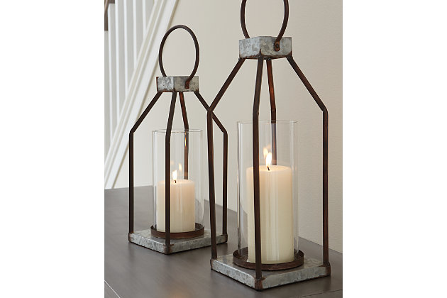 Whoever said you couldn’t illuminate in style? This set of Diedrick lanterns act as beautiful vessels for the romantic glow of pillar candles, whether placed in an indoor or outdoor space. The galvanized metal offers decor versatility, and the top metal handle and glass hurricane shade make it oh-so-easy to transport.Made of galvanized metal with antiqued finish and glass hurricane shade | Indoor/outdoor safe | Holds two 3" pillar candles (not included) | Clean with a soft, dry cloth