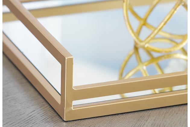 Crafted from metal, the Adria square tray with a mirrored glass base features raised railings along the circumference to ensure the safety of your favorite keepsakes. Versatile and visually elevating, this is a great choice for decor spaces with a contemporary feel and design.Metal frame with goldtone painted finish | Mirrored glass base | Interior use only