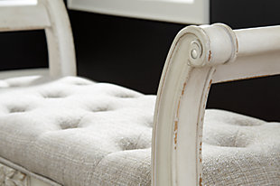 A classic to be cherished for years. The Realyn accent bench is a timeless treasure. Quality wood frame flaunts an antiqued white finish. Touches like the scrolled arms and floral applique give this piece so much character. You’ll love sitting on the cushiony, tufted seat in all of its sophistication.Tufted seat with foam cushion | Made of polyester | Wood frame | Estimated Assembly Time: 15 Minutes